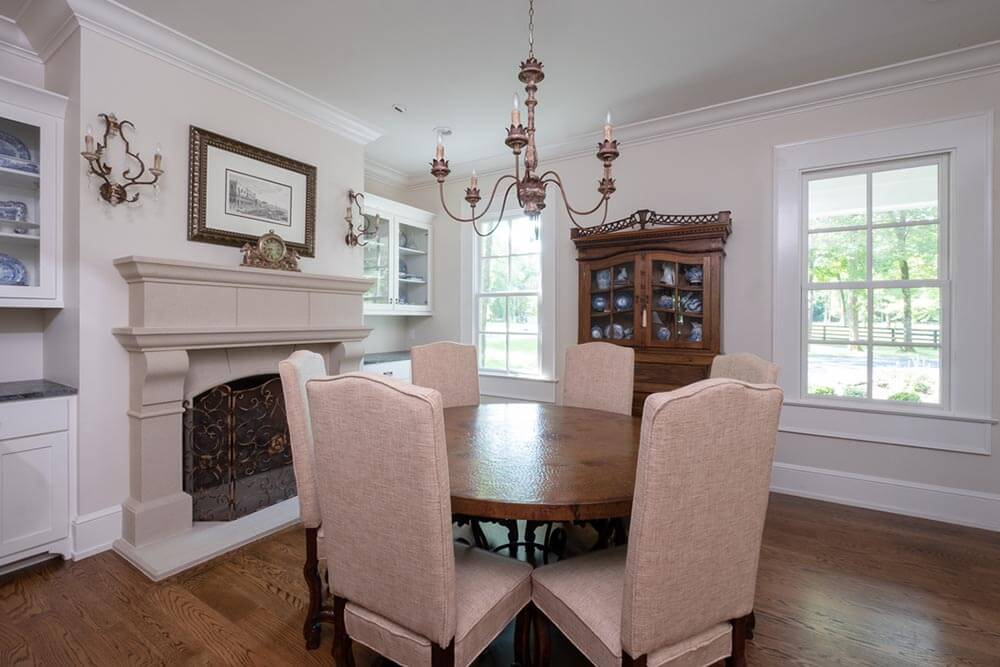 Strong, elaborate fireplace in a small dining room with classic furniture